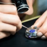 orologiaio con monocolo e pinzette aggiusta un orologio