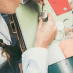 orologiaia con pinzette e attrezzatura varia ripara un orologio